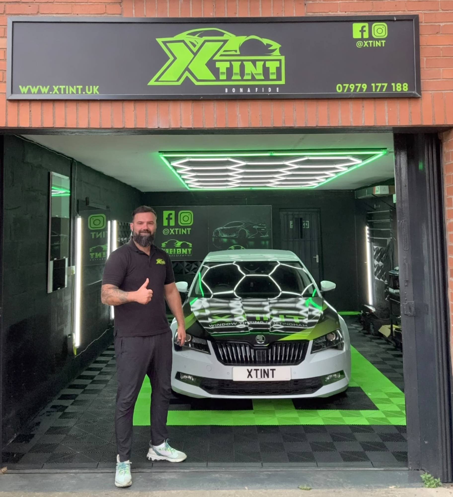 Cezar, founder of XTINT, giving a thumbs up outside the XTINT studio in Sherwood, Nottingham