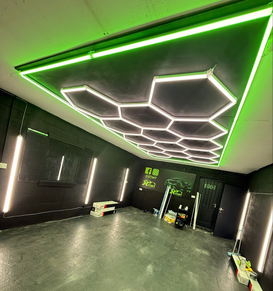 Inside the XTINT studio in Nottingham — hexagonal LED ceiling lighting, green neon trim and the branded XTINT wall